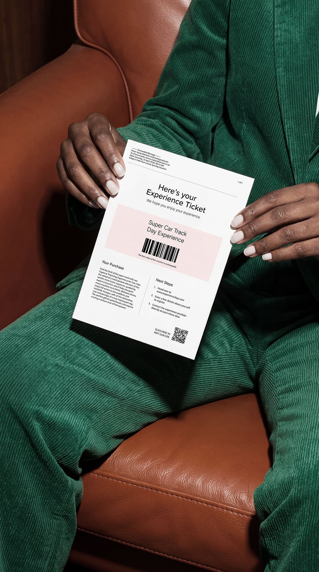 A plain printed experience voucher held in hand for a supercar driving day.